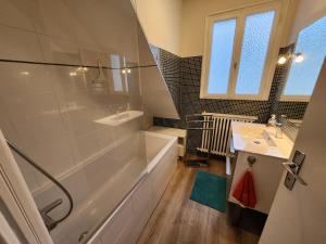 une salle de bain avec une baignoire, un lavabo et une douche dans l'établissement Grande maison en bord de mer, à Concarneau 17 autres photos