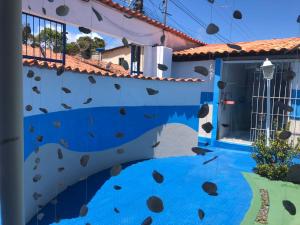 a mural on the side of a house with a swimming pool at kitnet & lazer in Pitimbu +8 photos