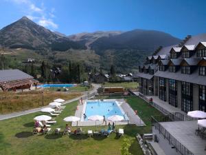 a resort with a swimming pool and mountains in the background at HG Cerler in Cerler