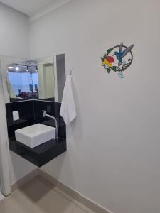 a bathroom with a sink and a mirror at Jequitibá Rosa - frente ao Mar na Praia de Meaípe, Guarapari in Guarapari +21 photos