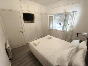 a white bedroom with a bed and a window at Céntrika in Mendoza