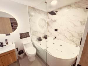 a bathroom with a tub and a toilet and a sink at Casa Provenza in Medellín