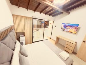 a bedroom with a bed and a desk and a window at Casa Provenza in Medellín