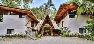 an exterior view of a house with a wooden roof at Conga Boutique Hotel in Puerto Viejo