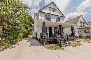 a white house with a porch and a driveway at Fully Renovated Modern 4Bedroom 3Bath Home Close to Downtown Cleveland Fully Furnished in Cleveland