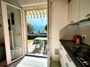 a kitchen with a door open to a patio with a table at La Meridiana sul Lago in Abbadia Lariana