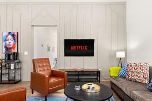Una sala de estar con un sofá y un televisor. en Stylish Home Nr Dt, Alamo, River Walk Games Wifi, en San Antonio