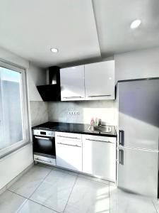 a kitchen with white cabinets and a stainless steel refrigerator at Apartment in Waldbronn