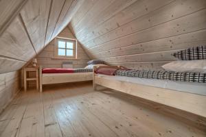 ザコパネにあるDomek NBD-bafiaの木造キャビン内のベッドルーム1室(ベッド2台付)