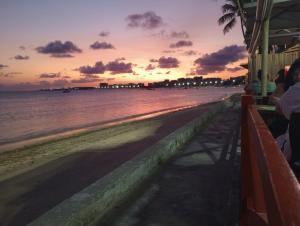 a view of the beach at sunset at Quarto casal em charmoso apto compartilhado in Maceió