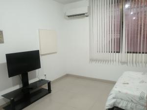 a white room with a tv and a bed at Económico práctico central in Cúcuta
