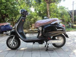 a motor scooter parked on a sidewalk at Villa puncak Terang in Giri