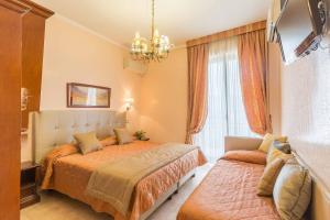 a bedroom with two beds and a chandelier at Hotel Aquila in Orte