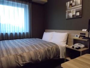 Voodi või voodid majutusasutuse Hotel Route-Inn Masuda toas