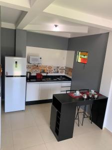eine Küche mit einem Kühlschrank und einem Tisch darin in der Unterkunft Stúdio Amarelo in Florianópolis