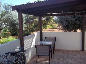 patio ze stołem, krzesłami i ogrodzeniem w obiekcie Villa Margarita w mieście Protaras