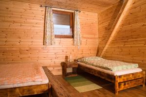 a bedroom with two beds in a log cabin at U Martinov in Poniky