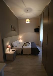 ein Schlafzimmer mit einem Bett und einem Tisch mit zwei Lampen in der Unterkunft Civico7 in Villa San Giovanni