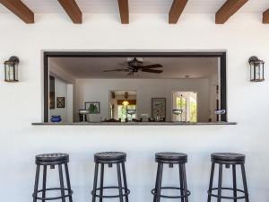 パーム・スプリングスにあるSan Jacinto Hacienda by Acme House Companyのスツール付きのバーの後ろの鏡