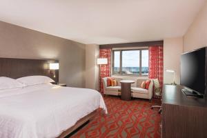 a hotel room with a bed and a flat screen tv at Sheraton Springfield Monarch Place Hotel in Springfield