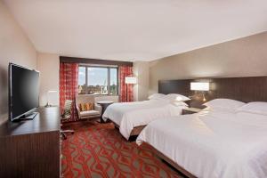 a hotel room with two beds and a flat screen tv at Sheraton Springfield Monarch Place Hotel in Springfield +18 photos