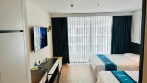 a hotel room with two beds and a window at Apec Mandala Luxury Phú Yên in Tuy Hoa