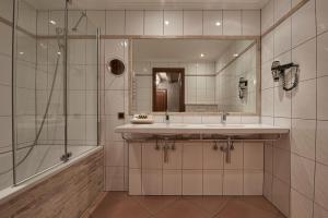 a bathroom with a sink and a shower and a mirror at Hotel d'Allèves in Geneva