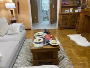 ein Wohnzimmer mit einem Tisch und Teller mit Lebensmitteln darauf in der Unterkunft Army Deluxe in Astorga