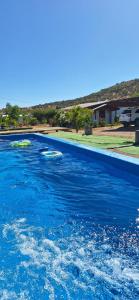 a large pool of blue water in a yard at Cabañas Tricahue in El Manzano