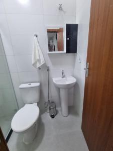a white bathroom with a toilet and a sink at Jacarandá de Minas Vista Mar Praia de Meaipe Guarapari in Guarapari +28 photos