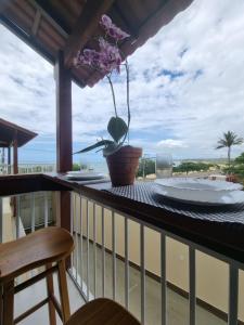 a table on a balcony with a view of the ocean at Jacarandá de Minas Vista Mar Praia de Meaipe Guarapari in Guarapari