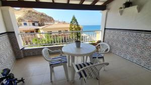 a table and chairs on a balcony with a view of the ocean at Apartamento Playa La Calica in San Juan de los Terreros +5 photos