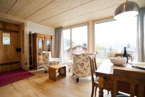 une salle à manger avec une table et des chaises et une grande fenêtre dans l'établissement Apartment Strohballenhaus, à Amden