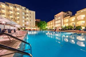 a large swimming pool in front of some buildings at Hotel Sport & Residenza in Cesenatico