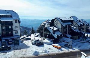 a group of buildings in the snow with cars parked at Gorštak in Kopaonik