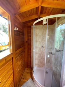 a bathroom with a shower in a wooden house at Glamping Brillo de Luna in Guatavita