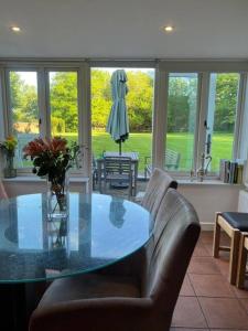 een eetkamer met een glazen tafel en lederen stoelen bij Bucking Lodge in Wisley
