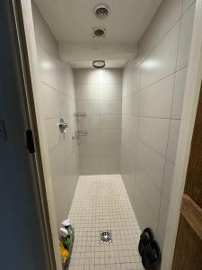 een badkamer met een douche en een tegelvloer bij Bucking Lodge in Wisley