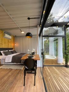 a bedroom with a bed and a table and a tub at Container Dos Sonhos in Rio Forcação