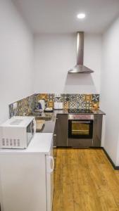 una cocina con estufa y microondas en Cilio House II, en Ponta Delgada