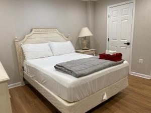 ein Schlafzimmer mit einem weißen Bett mit einer roten Decke darauf in der Unterkunft Cozy Townhome with luxury feelings in Frederick