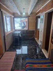 a room with a tile floor with a table and windows at Садиба Федорчуків За рікою1 in Sheshory