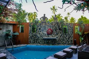 a fountain in front of a swimming pool with a statue at El Edén in Zipolite +24 photos