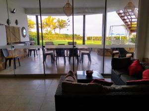 ein Wohnzimmer mit einem Tisch und einigen Stühlen in der Unterkunft Punta Sal, 1er piso frente al mar, lejos de rocas in La Bocana