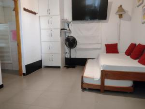 ein Schlafzimmer mit einem Bett und einem Fernseher an der Wand in der Unterkunft Punta Sal, 1er piso frente al mar, lejos de rocas in La Bocana