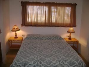 ein Schlafzimmer mit einem Bett und zwei Lampen an Tischen in der Unterkunft Punta Sal, 1er piso frente al mar, lejos de rocas in La Bocana