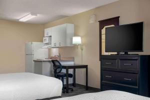 une chambre d'hôtel avec un lit et un bureau avec une télévision dans l'établissement Extended Stay America Suites - Sacramento - Arden Way, à Sacramento