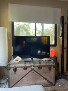 a flat screen tv on top of a wooden trunk at Melmac in Sauce de Portezuelo +9 photos