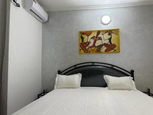 a bed with two pillows in a bedroom at Villa Paco in Mbour +61 photos