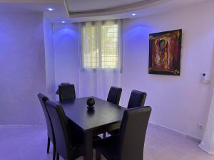 a dining room with a table and a painting on the wall at Villa Paco in Mbour